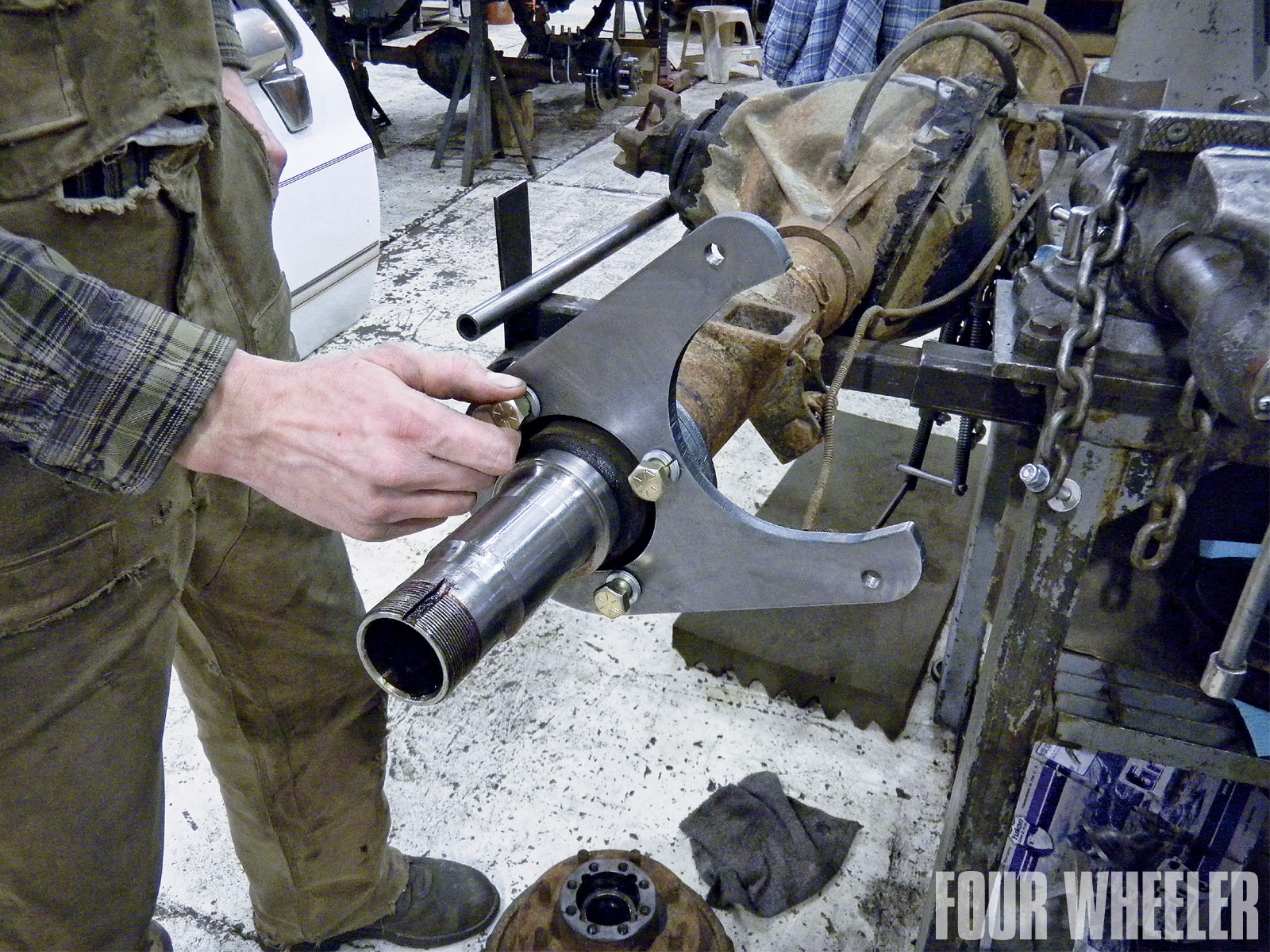 It is always a good idea to clean the spindle, axleshaft and axle bearings with a solvent prior to reassembly. You do not want dirt contaminating any of these critical wear surfaces. Once clean, the new caliper-mounting brackets are installed on the axle flanges. ORD supplies spacers that need to be installed between the bracket and housing flange. The bracket should be orientated approximately 45 degrees up at the rear of the housing, as shown here.