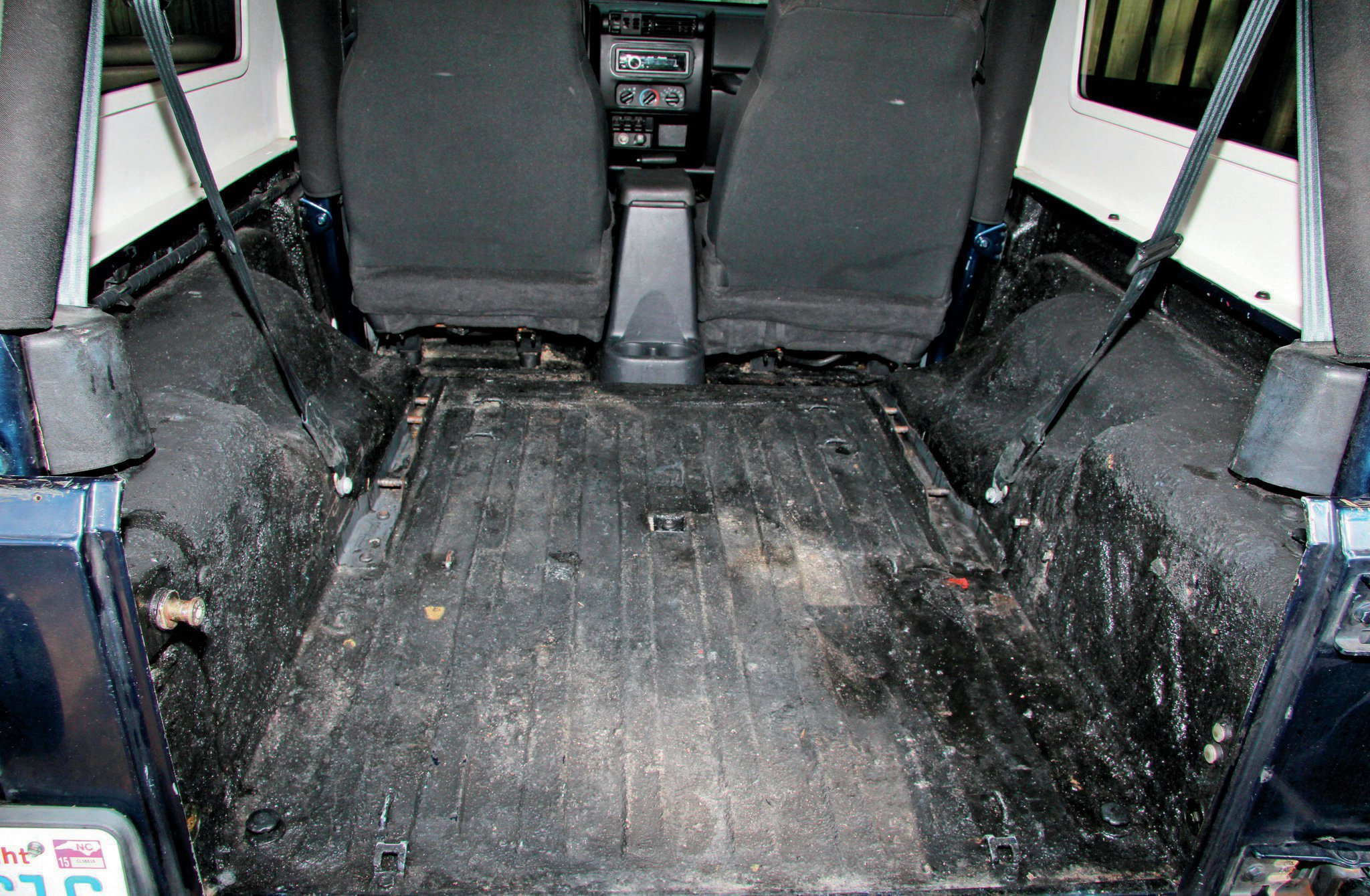 Our ’04 Unlimited was fit with a DIY bed liner, which had seen better days. Using some Simple Green and a brush, we scrubbed and vacuumed the inside of the Jeep to prep for the new BedRug.