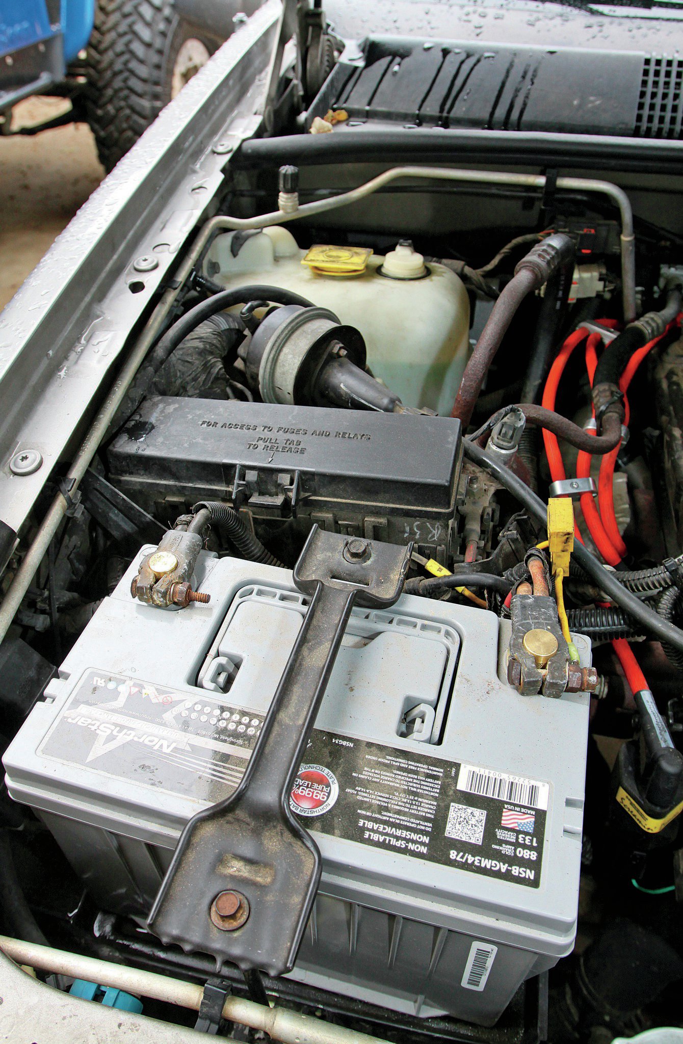 He cleaned the terminals (they were pretty corroded before), the wires were good, and he even put a new Northstar battery (northstarbatteries.com) in the Jeep because it kept saying “check battery.” He figured the battery that was in the Jeep when he got it was 10 years old, so better safe than sorry. However, the big problem was a loose nut right here on the power distribution center. I found it and laughed at him a lot. But we still only got 13.4 V with the Jeep running. I guess I have more searching to do.
